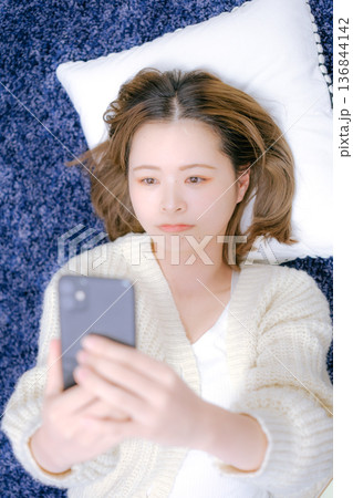 自宅でスマートフォンを持つ20代日本人女性 自宅でスマートフォンを持つ20代日本人女性 136844142