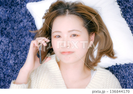 自宅でスマートフォン通話をする20代日本人女性 自宅でスマートフォン通話をする20代日本人女性 136844170