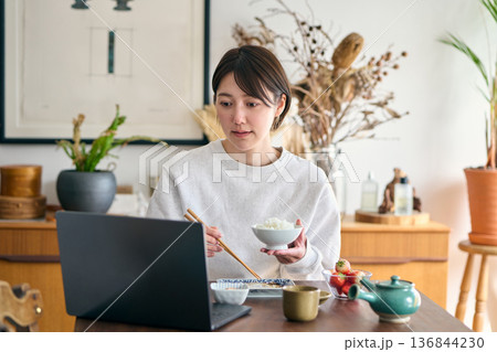 忙しい様子で朝食を食べる女性 忙しい様子で朝食を食べる女性 136844230