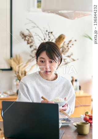 忙しい様子で朝食を食べる女性 忙しい様子で朝食を食べる女性 136844232