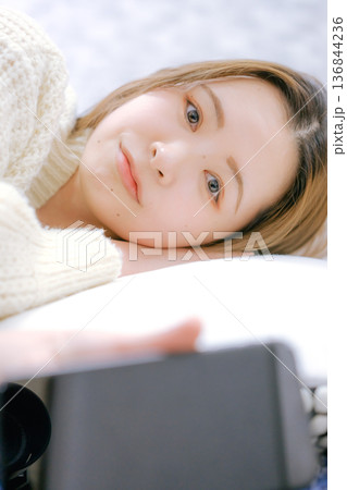 自宅でスマートフォンを見る20代日本人女性 136844236