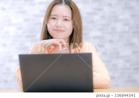 ノートパソコンを見ながら悩む20代日本人女性 ノートパソコンを見ながら悩む20代日本人女性 136844341