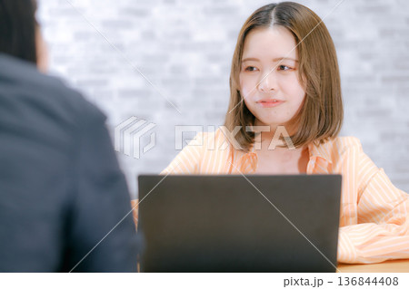 ノートパソコンを前に相談する20代日本人女性 ノートパソコンを前に相談する20代日本人女性 136844408