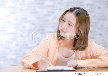 机で勉強する20代日本人女性 机で勉強する20代日本人女性 136844460