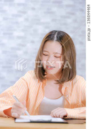 机で勉強する20代日本人女性 机で勉強する20代日本人女性 136844464
