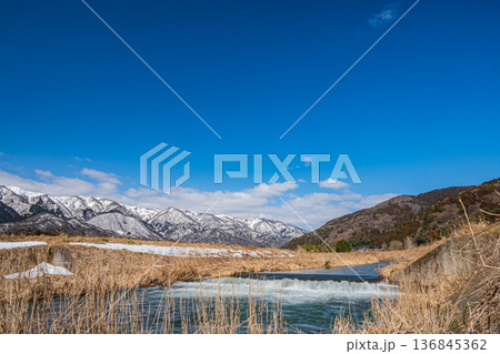 浅春の知内川と残雪の野坂山地　滋賀県高島市マキノ町 136845362