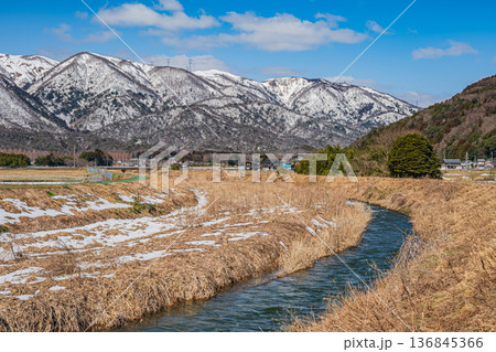 浅春の知内川と残雪の野坂山地　滋賀県高島市マキノ町 136845366
