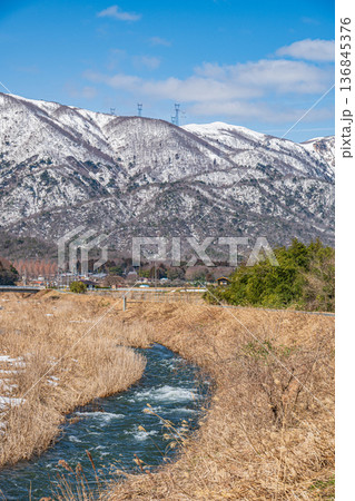 浅春の知内川と残雪の野坂山地　滋賀県高島市マキノ町 136845376