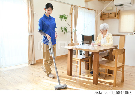 訪問介護で掃除をするアジア人介護士 訪問介護で掃除をするアジア人介護士 136845867