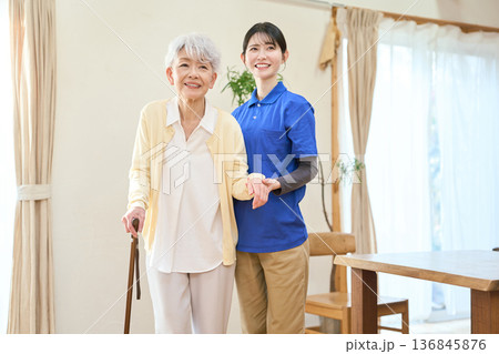 訪問介護で歩行介助をするアジア人介護士 訪問介護で歩行介助をするアジア人介護士 136845876