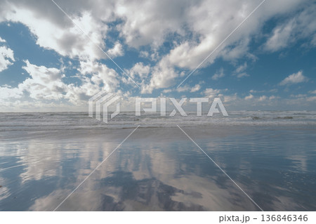 Marine ecosystems, sky reflections on a sandy beach, a spring storm, and copy space for text Marine ecosystems, sky reflections on a sandy beach, a spring storm, and copy space for text 136846346