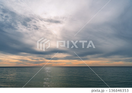 poster depicting a winter sea after a storm, calm and dark clouds 136846353