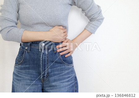 脇腹の痛みを感じる女性の手元 体調不良イメージ 脇腹の痛みを感じる女性の手元 体調不良イメージ 136846812
