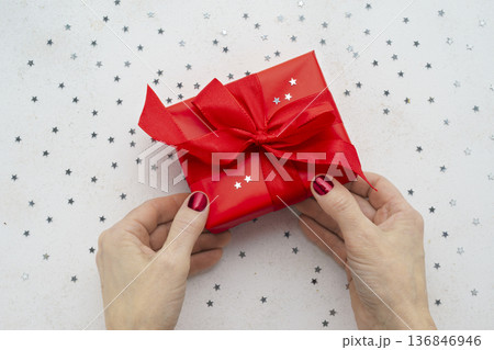 Female hands holding red Christmas gift box Female hands holding red Christmas gift box 136846946