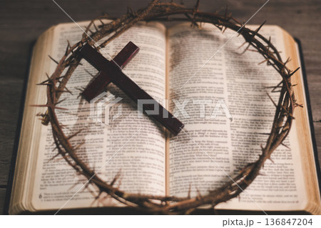 Wooden cross, crown of thorns and three iron nails on rustic wooden table, warm dramatic light and copy space, symbolizing crucifixion, sacrifice, Holy Week, Good Friday and Easter. Wooden cross, crown of thorns and three iron nails on rustic wooden table, warm dramatic light and copy space, symbolizing crucifixion, sacrifice, Holy Week, Good Friday and Easter. 136847204