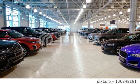 Car dealership showroom interior with rows of new vehicles. Car dealership showroom interior with rows of new vehicles. 136848161