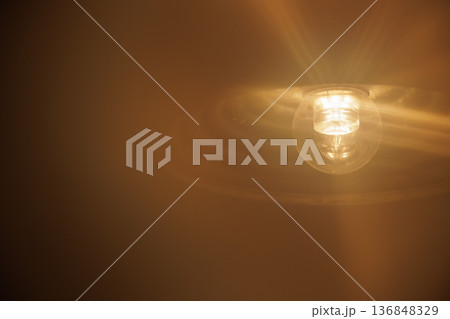 Bright glowing blurred electric light bulb and misty foreground 136848329