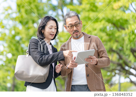 タブレットを見て話す2人　ビジネス 136848352