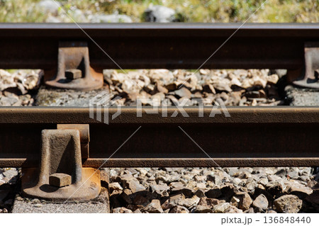 Close-up of metal railway tracks and track ballast Close-up of metal railway tracks and track ballast 136848440