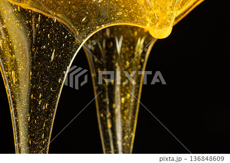 Luxury golden honey dripping on black background. Luxury golden honey dripping on black background. 136848609