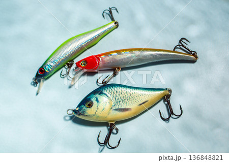 Flat lay of fishing equipment on blue background with water shadows. Close up of tackles and baits Flat lay of fishing equipment on blue background with water shadows. Close up of tackles and baits 136848821