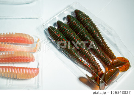 Flat lay of fishing equipment on white background. Close up of custom worms Flat lay of fishing equipment on white background. Close up of custom worms 136848827