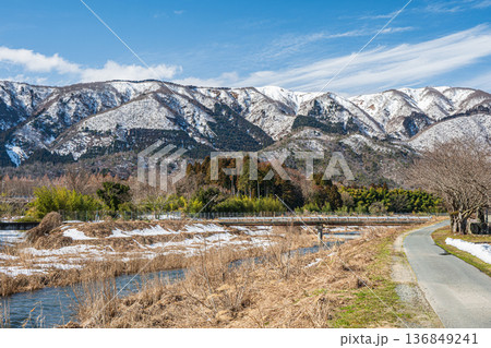 浅春の知内川と残雪の野坂山地　滋賀県高島市マキノ町 136849241
