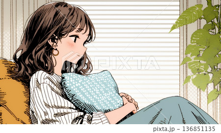 ソファでクッションを抱えてくつろぐ若い女性