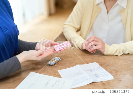 訪問介護で服薬介助をするアジア人介護士 136851373