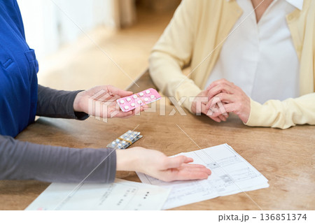 訪問介護で服薬介助をするアジア人介護士 136851374