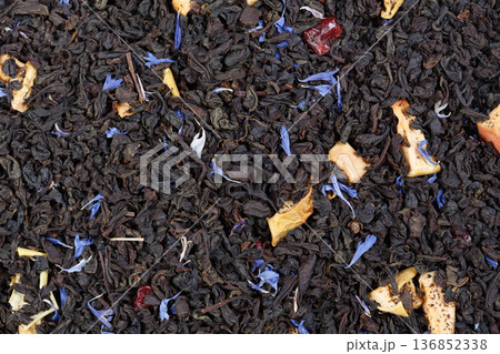 Dry green tea with slices of orange-peels and a bergamot. Can be used as background. Dry green tea with slices of orange-peels and a bergamot. Can be used as background. 136852338