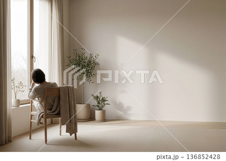 窓辺で静かな時間を過ごす女性・観葉植物のある白い部屋 136852428