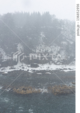 吹雪の川辺　雪が舞う冬の荒天風景 136852956