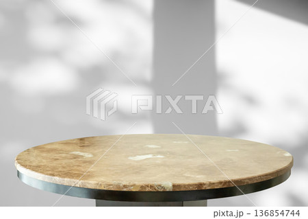 Round marble table top with tree leaves shadow drop on white wall background for mockup product display Round marble table top with tree leaves shadow drop on white wall background for mockup product display 136854744