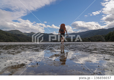 Barefoot hiker crossing tidal Awaroa Inlet on Abel Tasman Track, NZ Barefoot hiker crossing tidal Awaroa Inlet on Abel Tasman Track, NZ 136856037