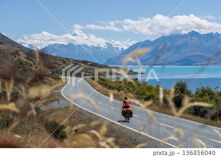 Cyclist touring scenic road to Mount Cook by Lake Pukaki, New Zealand 136856040