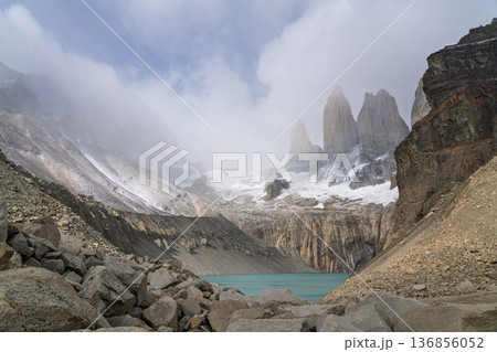 Iconic Torres del Paine spires shrouded in mist above glacial lake, Chile 136856052