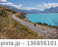 Wide view of cyclist on scenic road to Mount Cook by Lake Pukaki, NZ 136856101