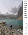 Hiker emerging from water below misty Torres del Paine, Patagonia, Chile 136856110