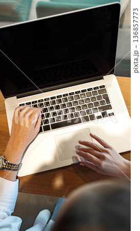 User works on laptop at a desk during daytime User works on laptop at a desk during daytime 136857773