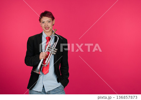 Young musician holding trumpet smiling at camera 136857873
