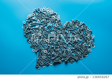 The metal heart is isolated on a blue background. The concept of cold bloodedness. Attachment material The metal heart is isolated on a blue background. The concept of cold bloodedness. Attachment material 136858267