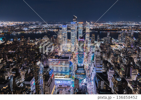 Night aerial view of Hudson Yards district and Midtown Manhattan with illuminated skyscrapers and busy avenues in New York City USA Night aerial view of Hudson Yards district and Midtown Manhattan with illuminated skyscrapers and busy avenues in New York City USA 136858452