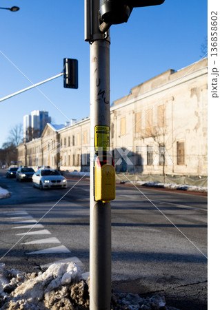Traffic light signals pedestrians at a crosswalk in a city street Traffic light signals pedestrians at a crosswalk in a city street 136858602
