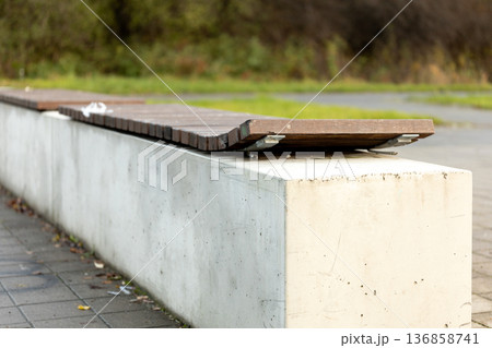Unique park bench design with wooden seating on a concrete base Unique park bench design with wooden seating on a concrete base 136858741
