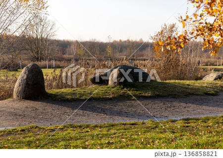 Large boulders sitting in a scenic park during autumn afternoon Large boulders sitting in a scenic park during autumn afternoon 136858821