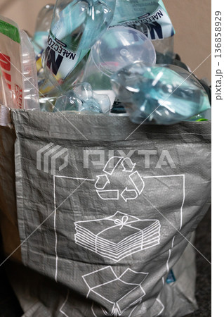 Trash bag full of plastic bottles and packaging at home in the evening 136858929