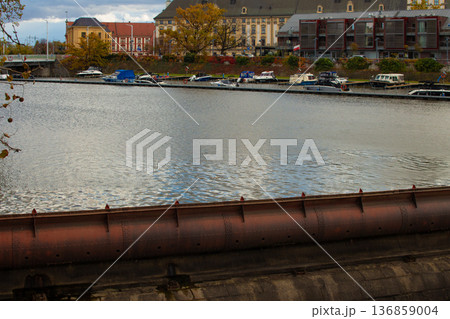 View of calm water with boats and autumn trees in the background View of calm water with boats and autumn trees in the background 136859004