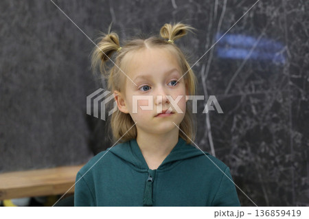 Beautiful blond child girl sitting in lounge. Young girl 6 years old portrait 136859419
