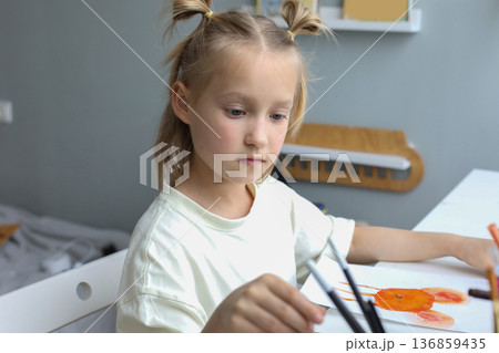 Playful young child painting at home. Close-up portrait of little girl indoor Playful young child painting at home. Close-up portrait of little girl indoor 136859435